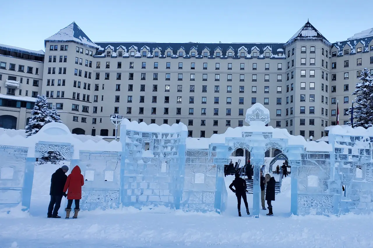 Group of people in colorful jackets posing playfully on a street with mountain backdrop.